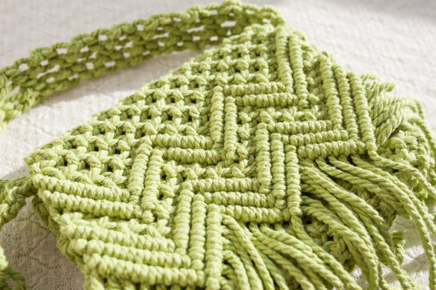 手工编织棉质十字袋。由棉绳制成的女性环保袋。斯堪的纳维亚风格的包。浅绿色配色，可持续时尚配饰。细节。特写图像图片下载