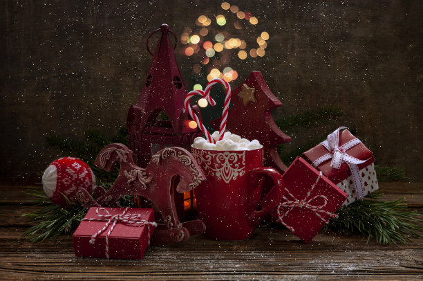 一个杯子的特写照片，里面有热饮和棉花糖，圣诞礼盒和圣诞装饰品。选择性对焦，浅景深，背景图片下载