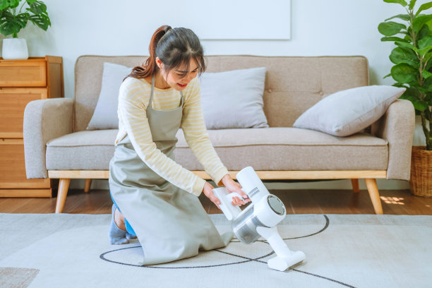 亚洲妇女使用真空吸尘器清洁地板。管理的概念图片下载