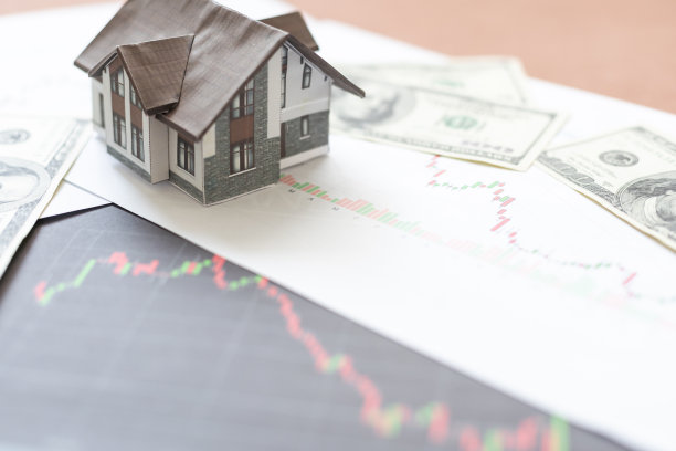 买卖房屋或房地产，房屋贷款，抵押和房地产投资的概念，微型房子在一堆美元纸币上印刷的价格图表。图片下载