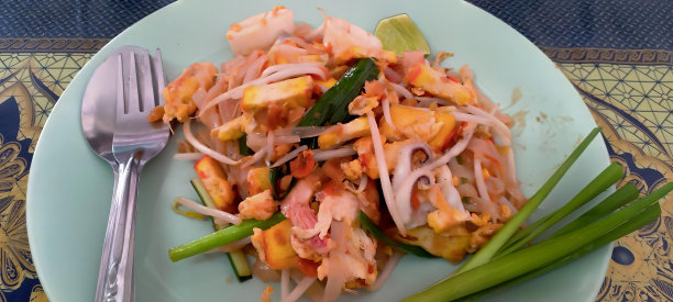 一盘食物与刀叉的照片，一盘食物与叉子和勺子放在桌子上。图片下载