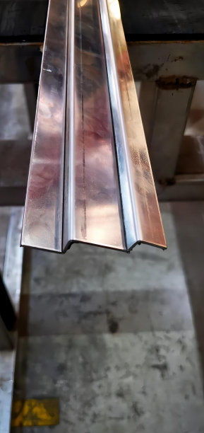 一张挂在天花板上的金属条的照片，一个车间里有一张钢桌子的木材厂钢条。图片下载