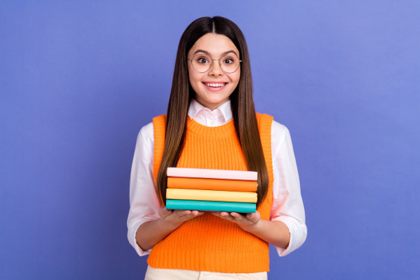 照片乐观惊讶时髦的女学生戴眼镜拿着一堆书资料信息孤立在紫色的背景图片下载