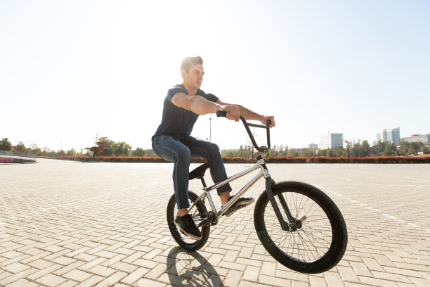 街头肖像一位骑手在街道上跳跃，背景是城市景观。图片下载