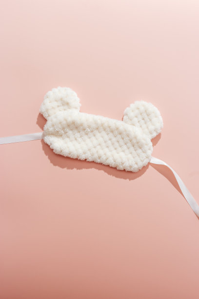 睡眠面膜从浅毛在粉红色的颜色梯度背景。静物细节，舒适的生活方式照片。蓬松的眼罩是最好的睡眠。家的舒适和健康的概念，最好的睡眠图片下载