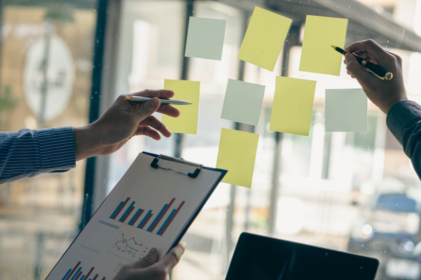 会议室玻璃上的便签，商人用手指着笔记本，用各种便利贴特写图片写下信息或会议主题图片下载