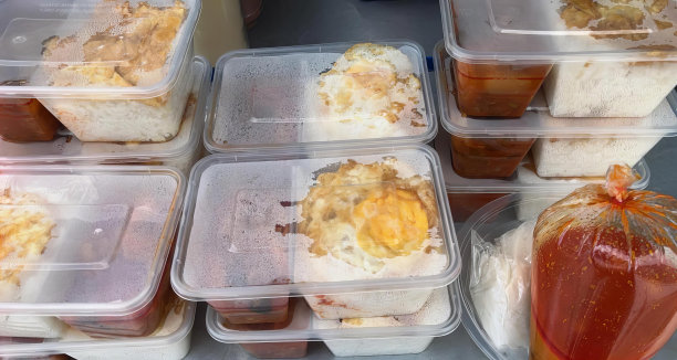 一张桌子的照片，桌子上放着盛着食物的塑料容器和一个塑料袋。图片下载