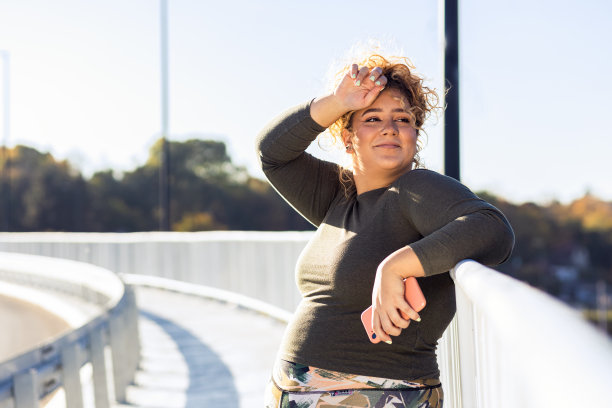 年轻大码女性跑步后休息的照片。图片下载