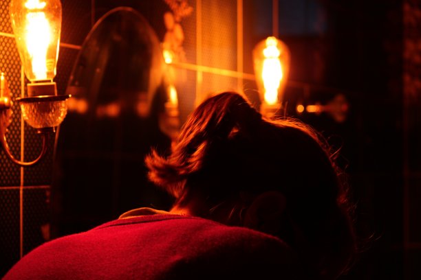 在工业照明的环境中，一个低着头的女人的照片图片下载