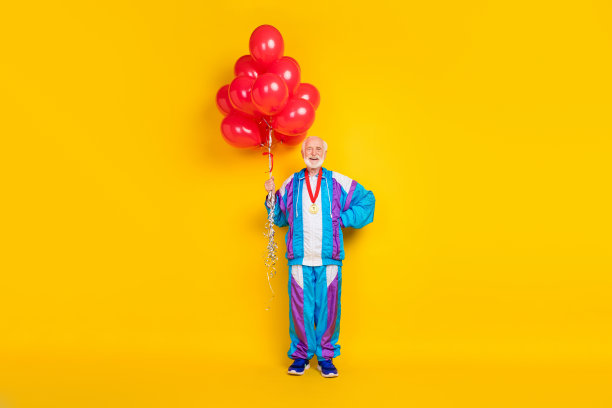 全长照片的年长男子锻炼举行许多球充气氦气开放新的体育购物中心孤立在黄色背景图片下载