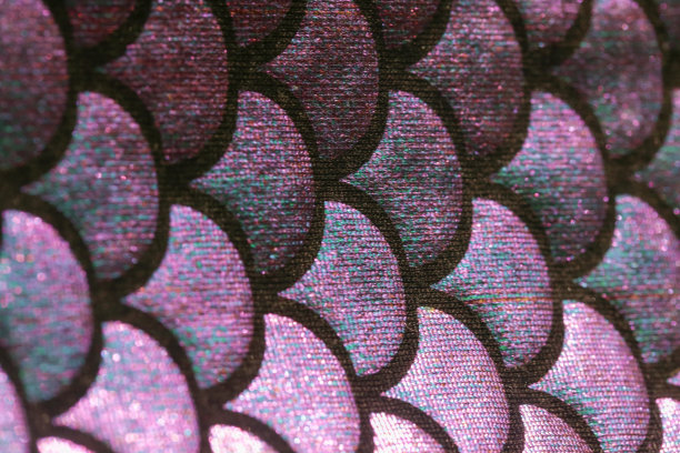 美人鱼的尾巴图案，近距离看。闪亮的氨纶鱼皮纹理。为女孩设计的纺织品。图片下载