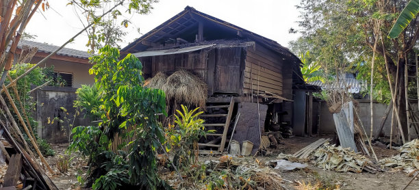 一张院子里有梯子的房子的照片，一张前景里有梯子和梯子的木材厂的照片。图片下载