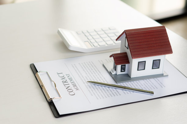 带笔记本电脑的木桌，房子钥匙，带笔的剪贴板，房子模型和绿树计算器，房地产概念。特写照片图片下载