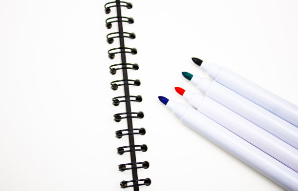 笔记本上的彩色记号笔。在笔记本、文具、办公用品上写字的记号笔。图片下载