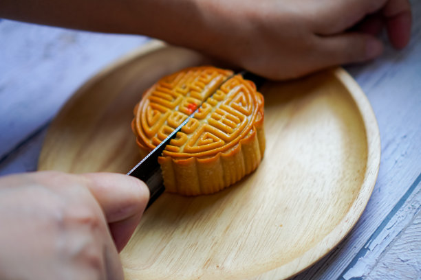 图为示范如何在餐盘上切咸蛋月饼。图片下载