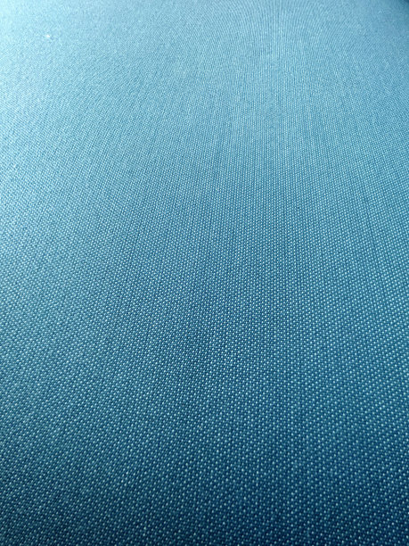 蓝色的渐变。光滑的蓝色面料。牛仔质地。织物抽象背景。单色纹理背景。蓝色色调的棉质材料或织物。高质量的照片。图片下载