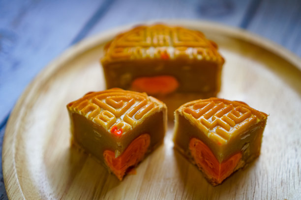 正餐盘上切成小块的咸蛋月饼的侧视图。图片下载