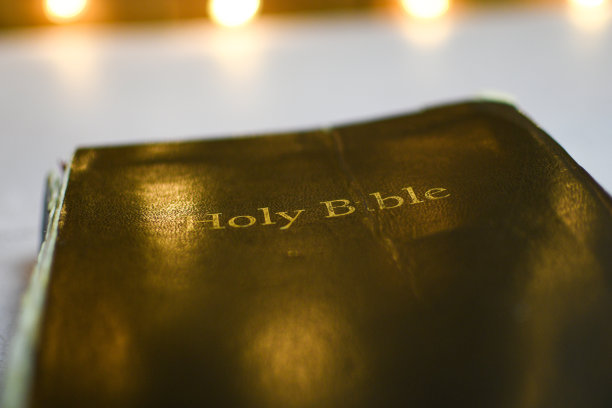 圣经在白色背景与圣诞灯反映在封面上图片下载