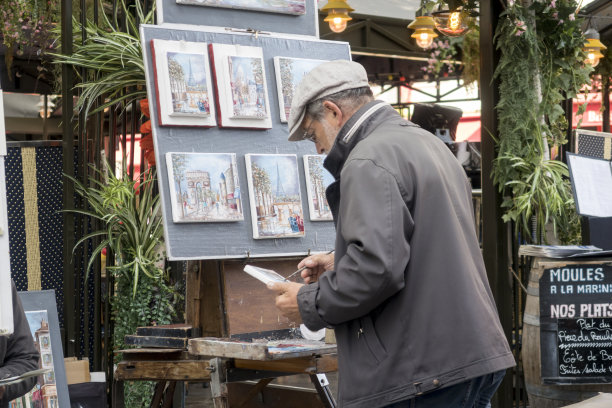 一名巴黎艺术家在他的户外摊位上卖画，在巴黎蒙马特图片下载