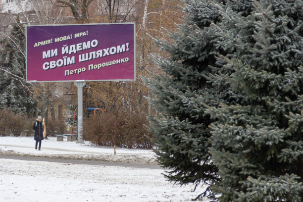 雪覆盖的城市景观与广告牌广告竞选活动的总统的乌克兰。文本:军队!语言!信仰!我们走自己的路!秘书波罗申科图片下载