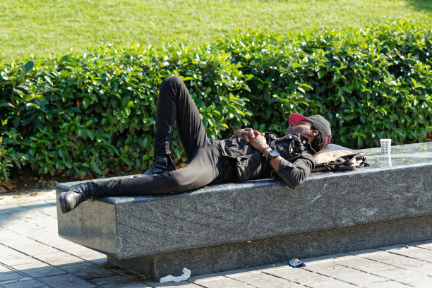 在公园长椅上睡觉的年轻人图片下载