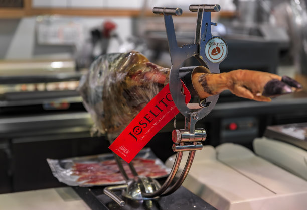 西班牙马德里当地市场上展示的伊比利亚塞拉诺火腿整条腿图片下载