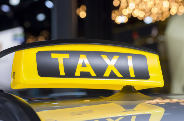 出租车在等人。出租车的标志在车顶。图片下载