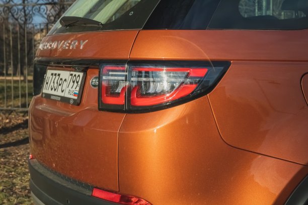 橙色的路虎发现运动2020停在滨水区。外观优质的英国SUV。四分之三的背面视图。图片下载