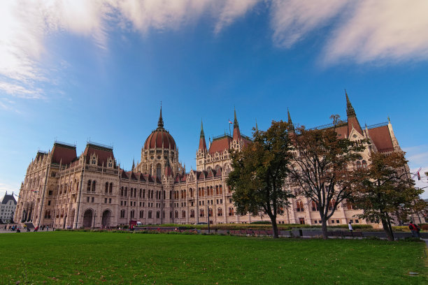 美丽的风景照片的匈牙利议会大楼对彩色戏剧性的天空。前景是绿色的草坪。布达佩斯著名的旅游景点和旅游目的地图片下载