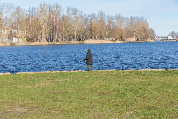 城市,里加,拉脱维亚。在河边，一个渔夫在捕鱼。旅行的照片。图片下载