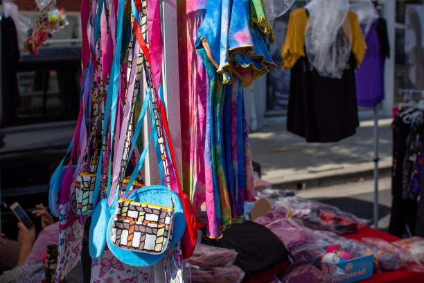 在欧文斯茅斯大街的卡诺加公园农贸市场(Canoga Park Farmer’s Market)的一个工艺品摊位上，为顾客悬挂着五颜六色的发带和钱包。图片下载