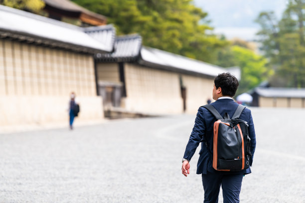 商人背着背包走在通往京都皇宫入口的街道上图片下载