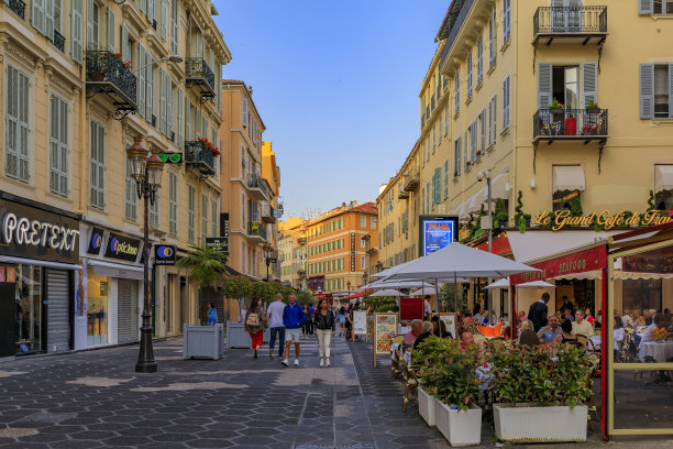 游客参观法国尼斯步行区，商业地标拥有餐厅和传统房屋商店图片下载