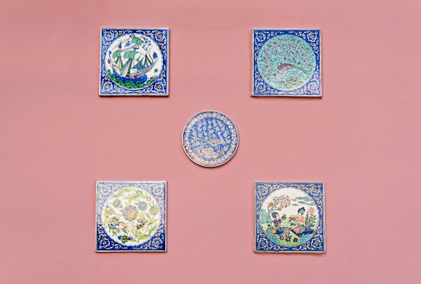 粉红色墙壁上有手绘瓷砖和带有神话情节的玫瑰花结图片下载