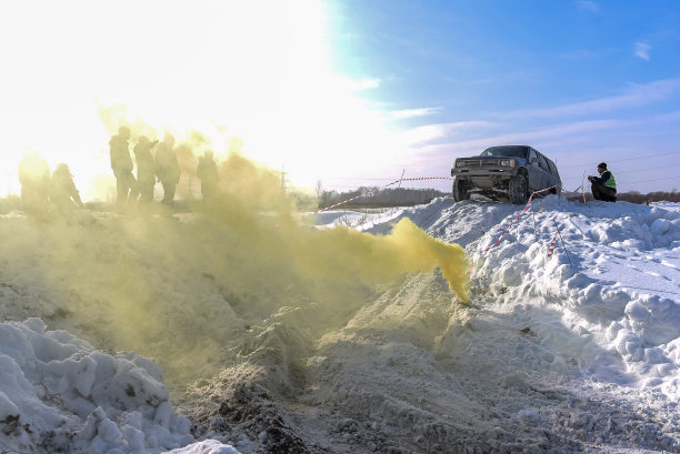 越野越野车“丰田4Runner Fourrunner 4x4”骑在一座雪山上，前面是五颜六色的黄色烟雾。图片下载