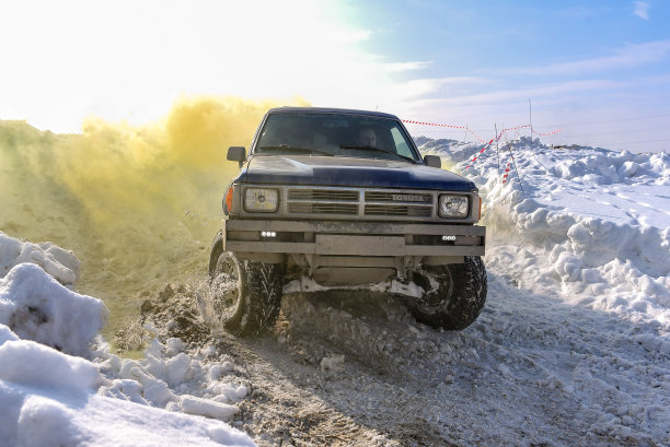 越野越野车“丰田4跑四跑4x4”在冬天的雪地上在黄色的烟雾在阳光明媚的雾霾中。图片下载