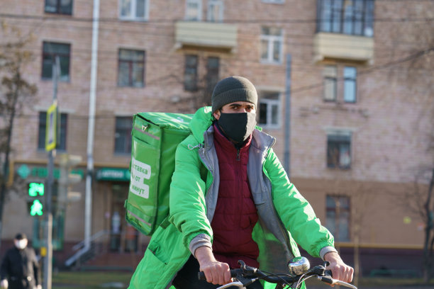 白天在街道上拍摄的快递员照片。冠状病毒大流行。图片下载