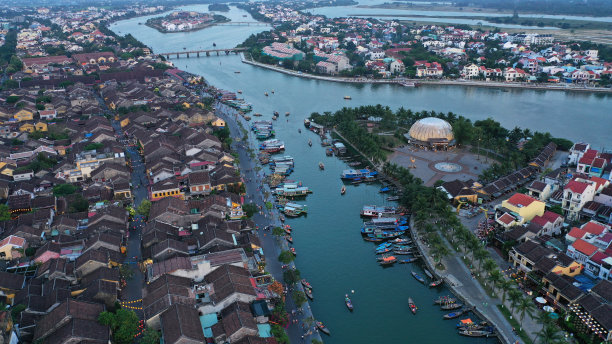 会城鸟瞰图日落时，在杜本河上的一个古老的城镇，广南省，越南。联合国教科文组织世界遗产。许多船停泊在岸边，桥，越南房子的图片。图片下载