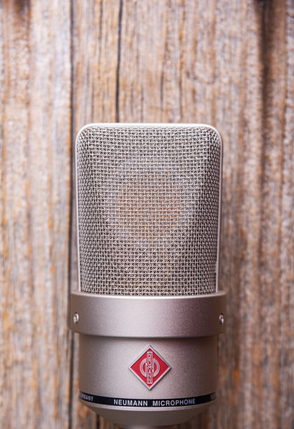 木质背景上的Neumann TLM 103大振膜电容录音棚麦克风图片下载
