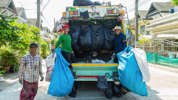 图片组的亚洲垃圾收集看着相机，而工作在一辆卡车在村庄早上。图片下载