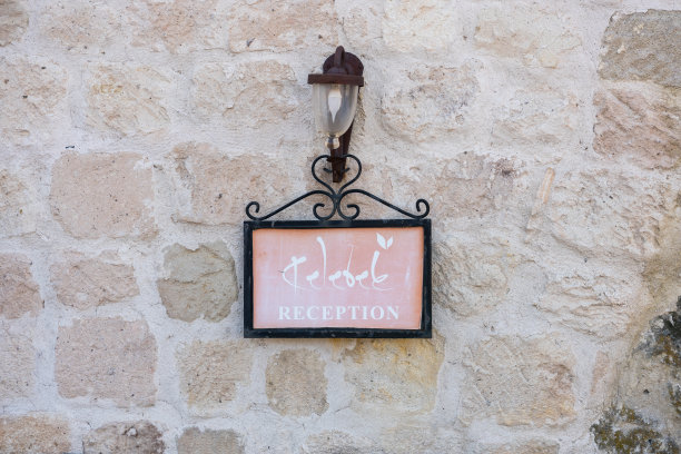 土耳其卡帕多西亚戈雷米的一堵石墙上的酒店标志。图片下载