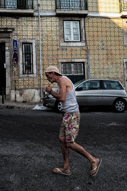 一个男人在里斯本的街道上抽烟。图片下载