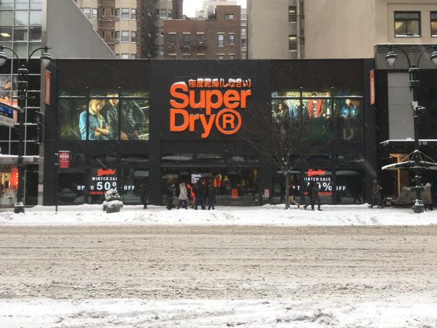 一场暴风雪过后，曼哈顿中城34街的超级干货商店。一场暴风雪过后，人们经过超级干燥百货商店。图片下载