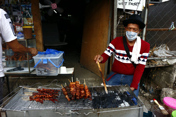 街头小吃摊贩沿着人行道烤制并出售各种鸡肉、猪肉和内脏图片下载
