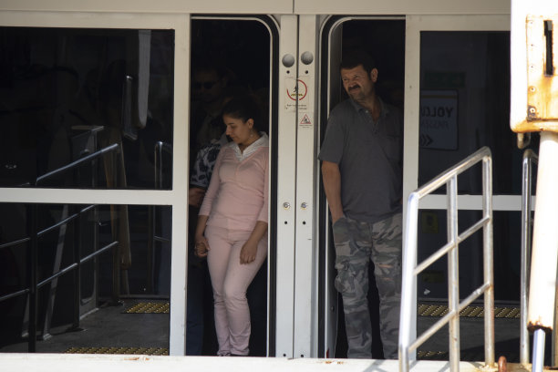 乘客通过渡船打开的大门下车。这张照片是在一个阳光明媚的日子里拍的。图片下载