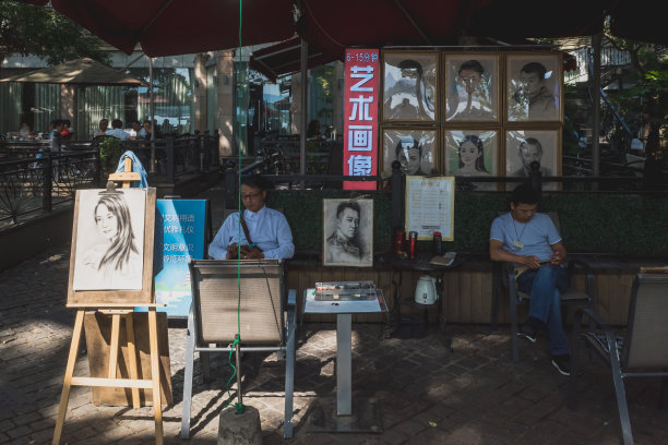 在西湖景区湖滨路附近，街头艺术家们站在画像上图片下载