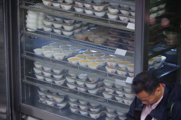 双皮牛奶和其他传统的香港甜品碗在粤菜餐厅的货架上图片下载