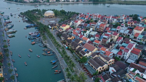会城鸟瞰图日落时，在杜本河上的一个古老的城镇，广南省，越南。联合国教科文组织世界遗产。许多船停泊在岸边，桥，越南房子的图片。图片下载