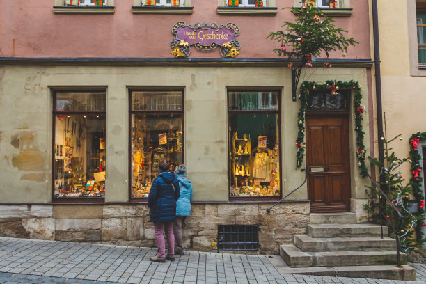 在德国陶伯河河畔的罗滕堡，人们看着装饰得灯火辉煌的商店橱窗图片下载