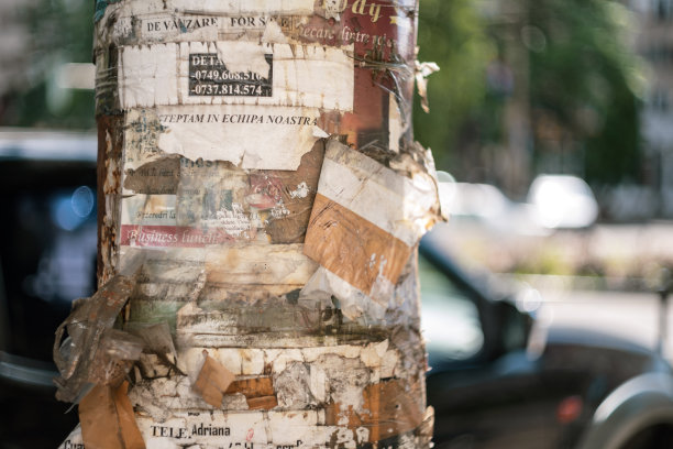 街道灯杆上有许多撕破的广告和招聘广告图片下载